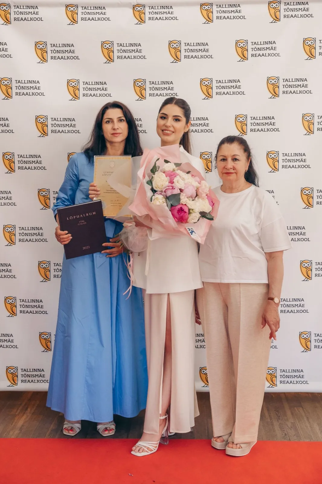 Выпускница с семьёй на фоне пресс-стены